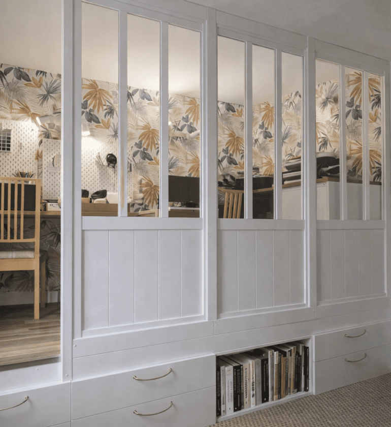 Espace travail aménagé sur estrade intégrant des rangements et verrière